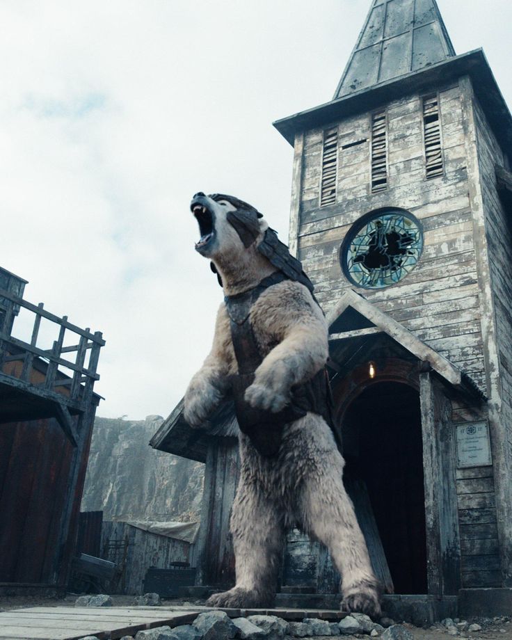 a large bear standing on its hind legs in front of a building with a clock