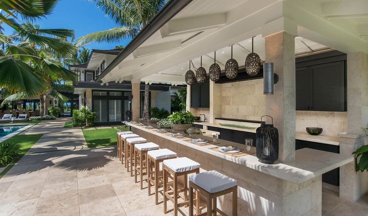 an outdoor bar with lots of stools next to a swimming pool