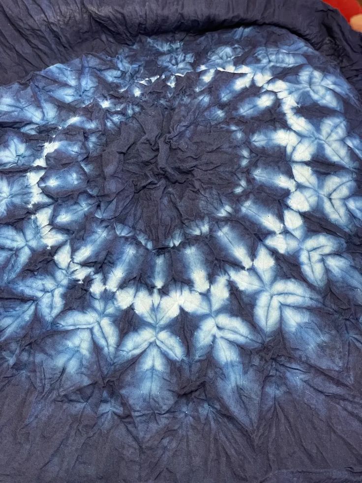 a blue and white tie - dyed comforter on a bed