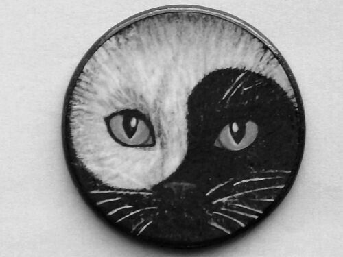 a black and white cat's face on a button