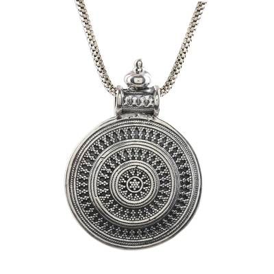 Shivani Choudhary designs this pendant with traditional Indian jewelry motifs including rawa which are tiny silver granules that are used to create patterns. Artisans craft this dramatic round pendant from sterling silver with an ornate bail. The pendant centers a wide sterling box chain. Traditional Engraved Flower Pendant Necklace, Traditional Sterling Silver Flower Pendant Necklace, Festival Medallion Amulet Jewelry, Intricate Design Amulet Necklace With Round Pendant, Intricate Round Pendant Amulet Necklace, Amulet Necklace With Intricate Round Pendant, Antique Silver Amulet Jewelry With Large Pendant, Ceremonial Necklace With Intricate Round Pendant, Traditional Silver Jewelry With Large Pendant