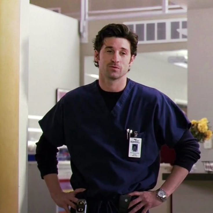 a man in scrubs standing with his hands on his hips