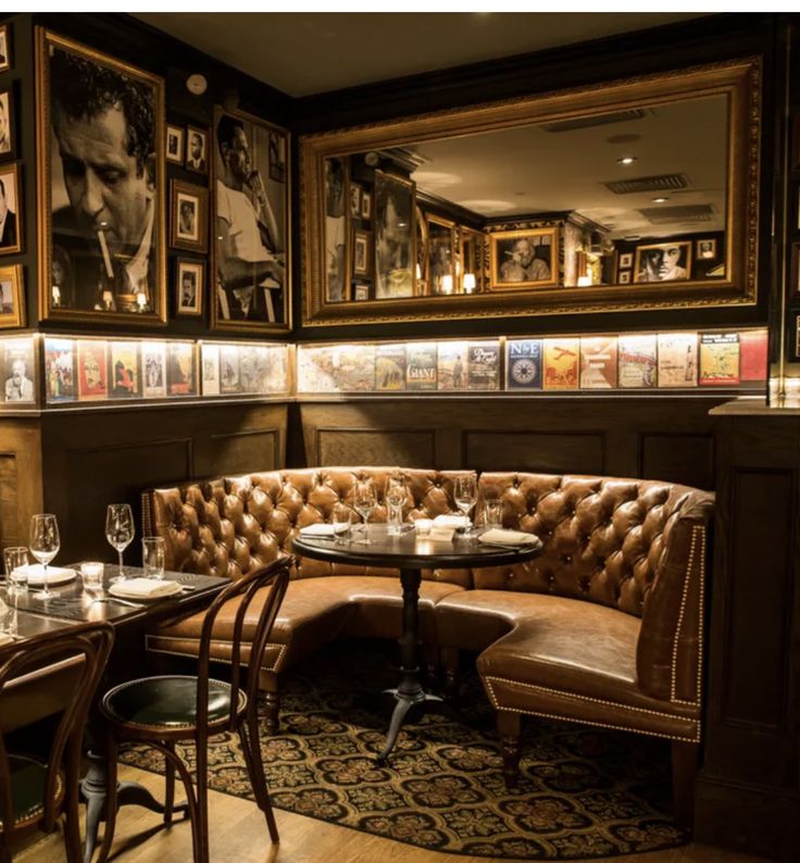 a restaurant with tables, chairs and pictures hanging on the wall above it's booth