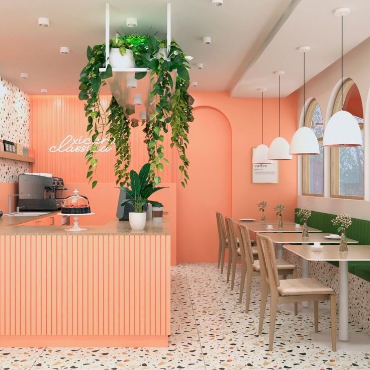 the interior of a restaurant with pink walls and green plants hanging over the bar area