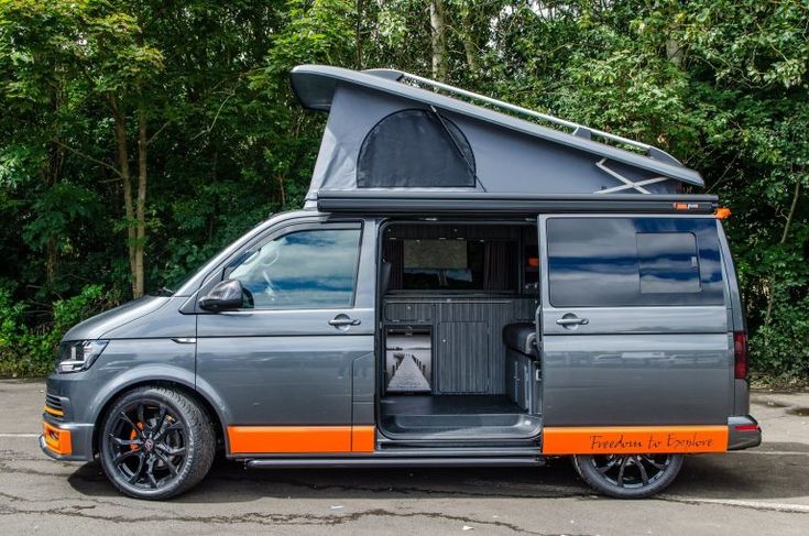 an orange and gray van parked in a parking lot with its door open to the side