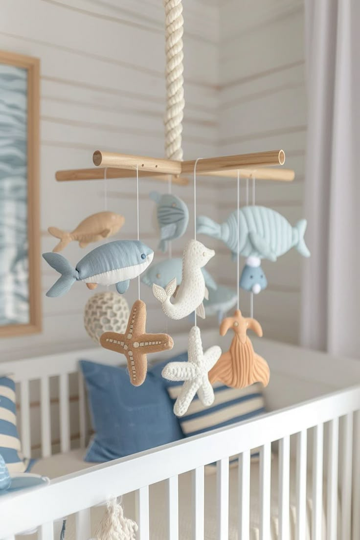 a baby crib with sea animals hanging from it's sides and on top of the bed