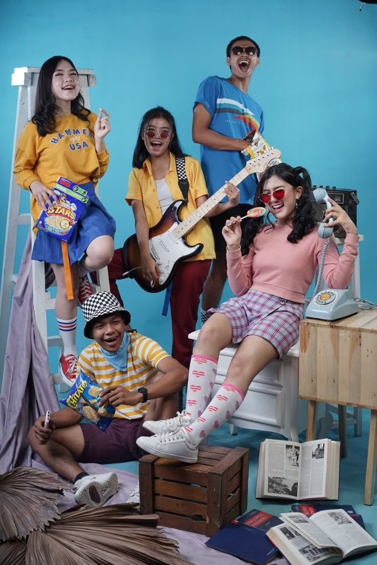 a group of people sitting on top of a chair with guitars in front of them