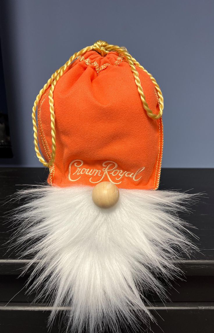 an orange santa hat with white fur and gold trimmings sits on top of a black table