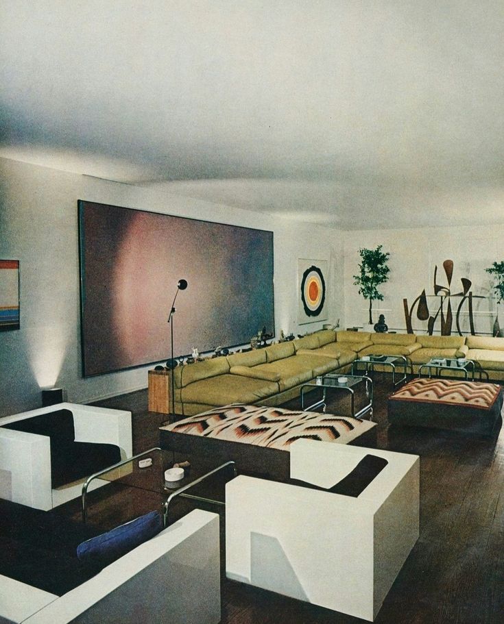 a living room filled with lots of furniture next to a large painting on the wall