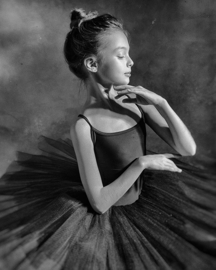 an old photo of a young ballerina in black and white with her hands on her hips