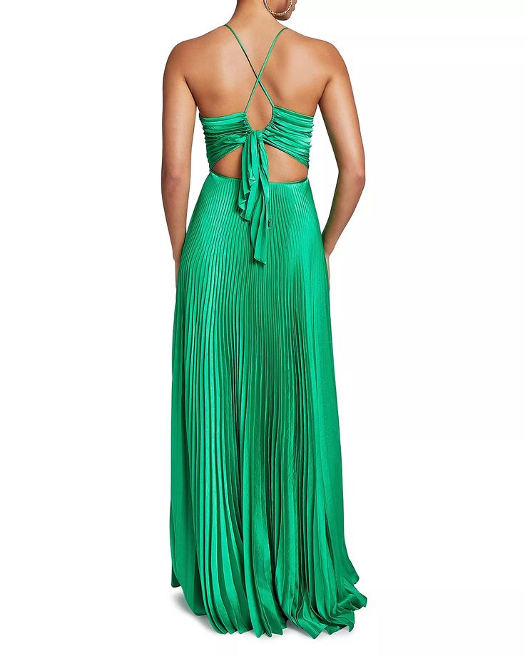 a woman wearing a green dress with a halter top and pleated skirt, back view