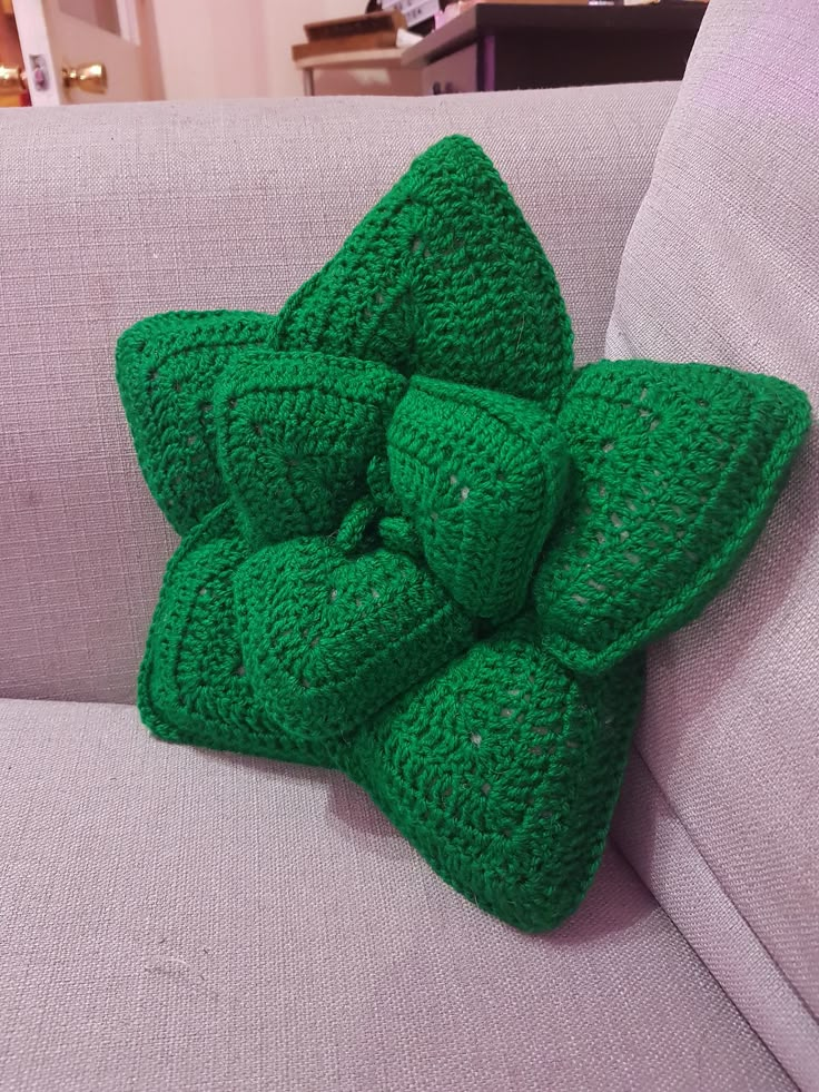 a crocheted green bow on the back of a couch