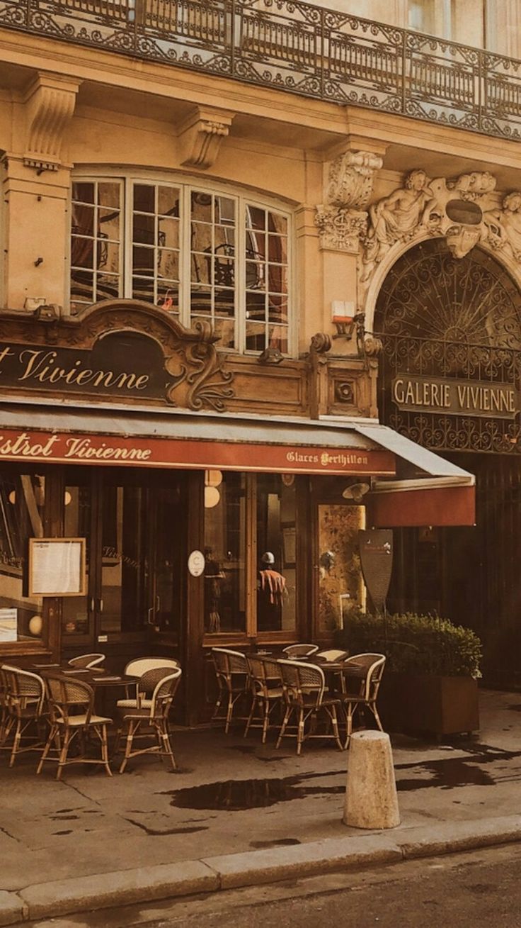 an old building with tables and chairs outside