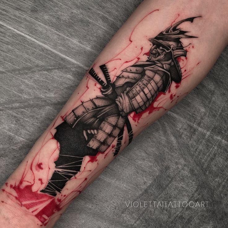 a man's arm with a black and red ink tattoo on it, depicting a samurai