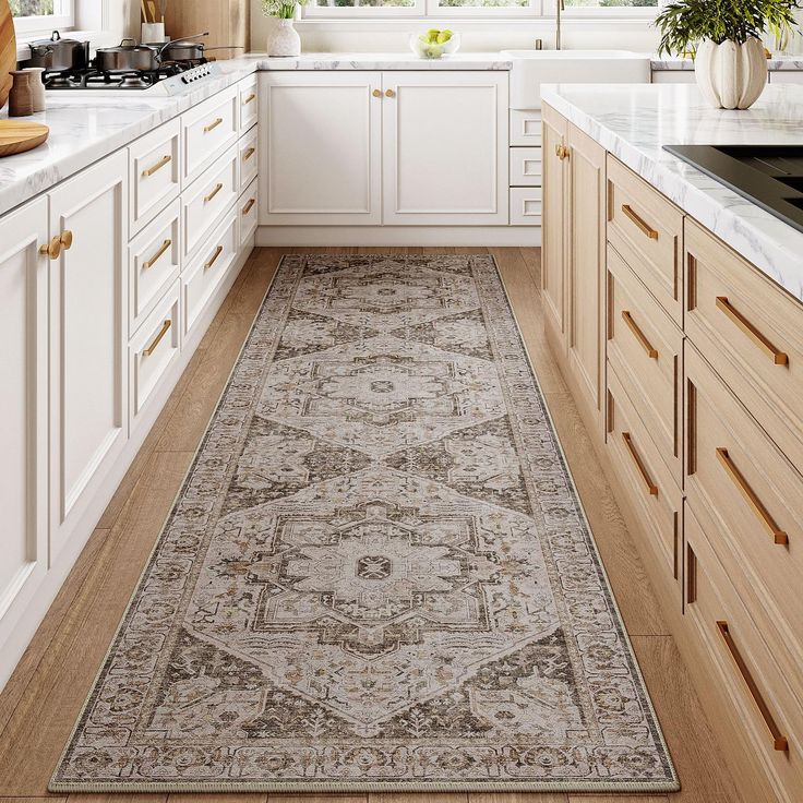 a kitchen with white cabinets and beige rugs on the floor in front of windows