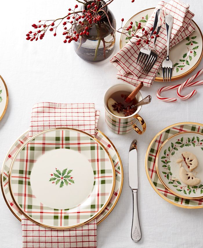 a table set for christmas with plates, cups and utensils