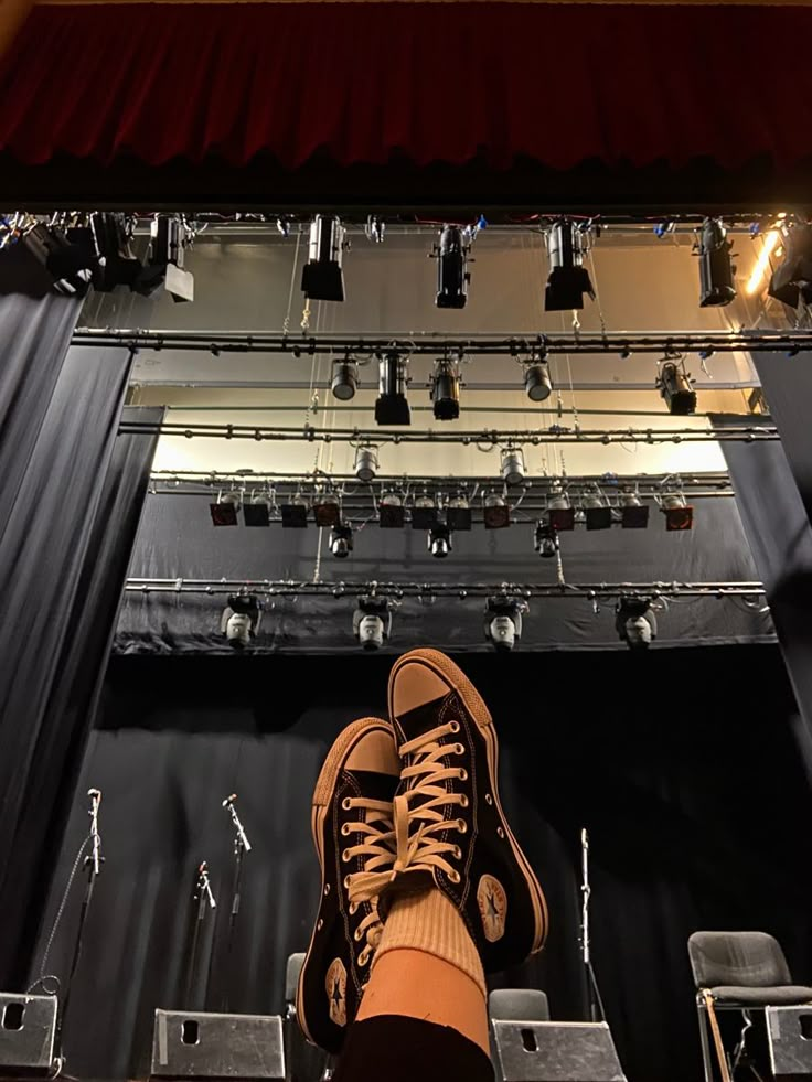 a person standing on top of a stage with their feet propped up in the air