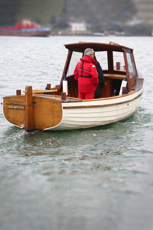 a man in a red jacket is on a small boat