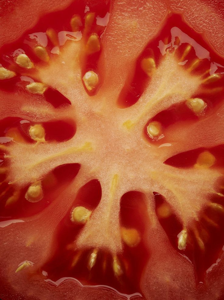 a close up view of a tomato that has been cut in half with the seeds still attached