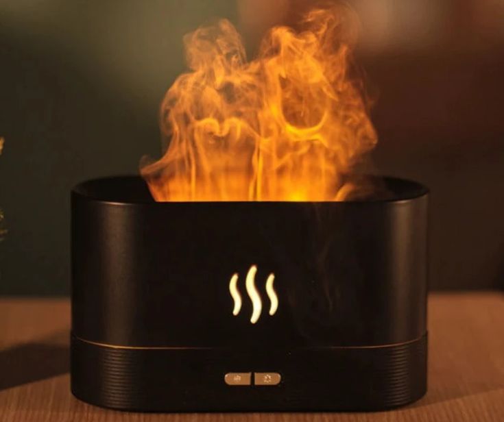 a fire burning inside of a black container on top of a table