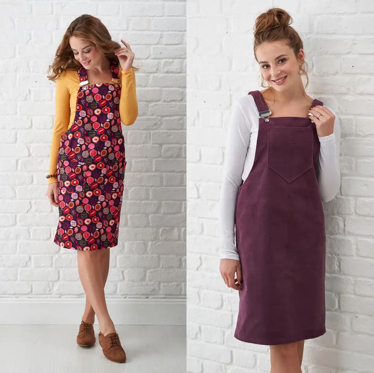 two women standing next to each other in front of a white brick wall and one wearing an apron