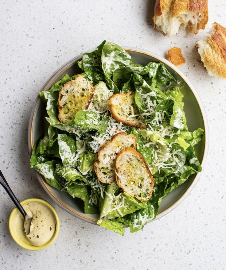 a salad with bread and dressing on the side