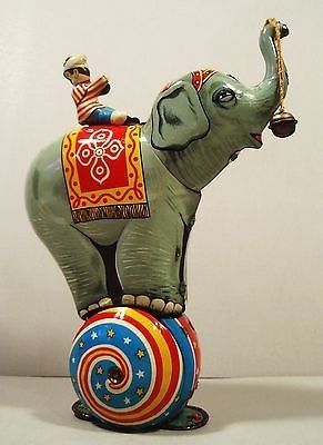 an elephant figurine sitting on top of a ball with a red, white and blue design