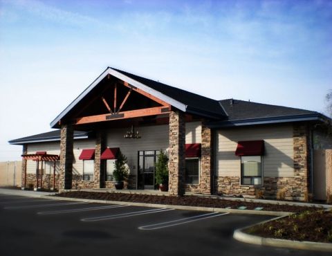 the front of a restaurant with stone pillars and red awnings on it's roof