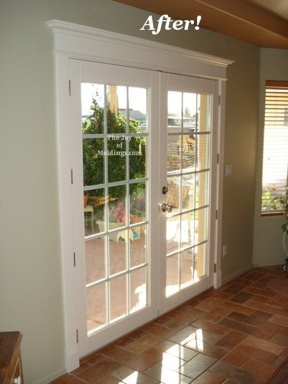 an empty living room with french doors and tile flooring