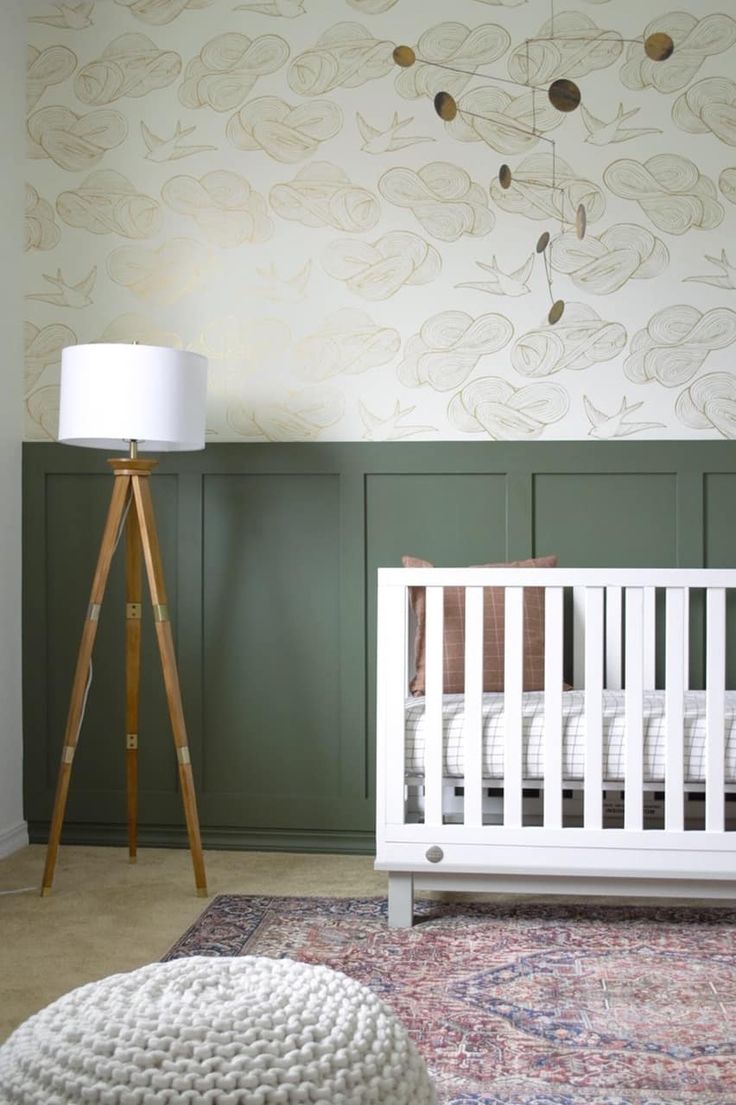 a white crib in a room with green paneling on the walls and a floor lamp next to it