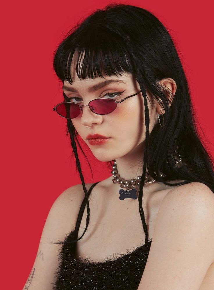 a woman with long black hair wearing red sunglasses and a choker on her neck