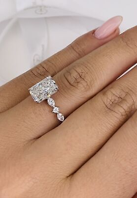 a woman's hand with a diamond ring on top of her finger and the other hand holding an engagement ring