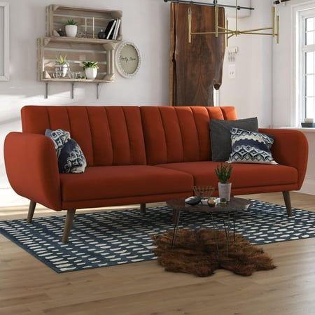 a living room with an orange couch and rug