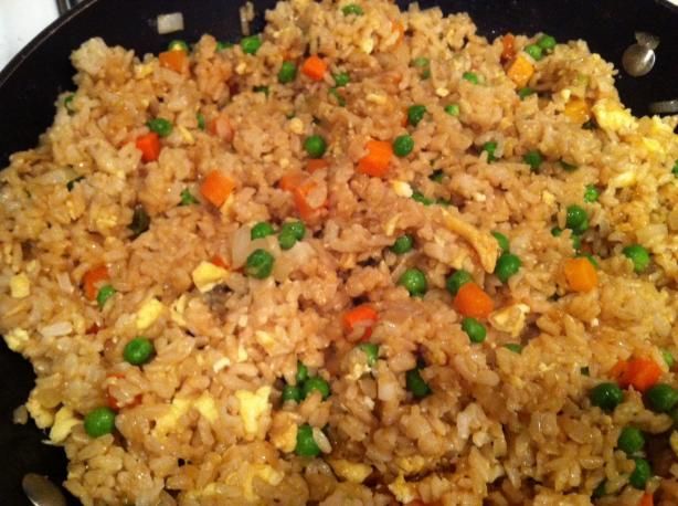 rice with peas and carrots in a skillet ready to be cooked for dinner