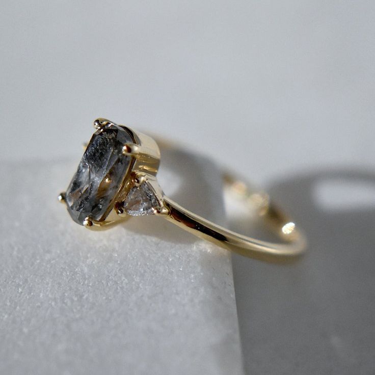 a yellow gold ring with two diamonds on it