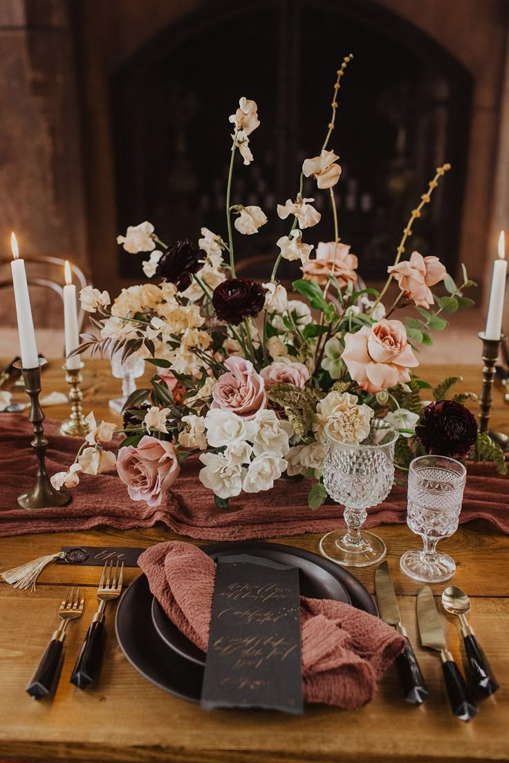 the table is set with flowers, candles and napkins for dinner guests to enjoy