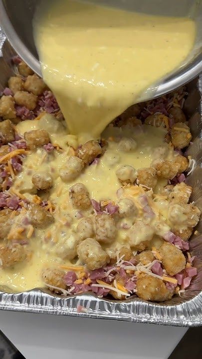 someone is pouring cheese on some food in a metal pan and it looks like they are going to eat something