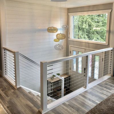 the inside of a mobile home with stairs and railings leading up to the second floor