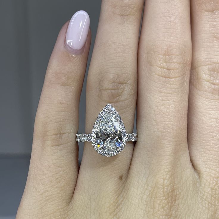 a woman's hand with a ring on it and a diamond in the middle