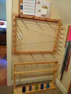 a weaving machine is sitting on the floor in front of a wall with several items