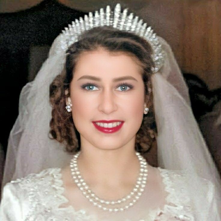 a woman in a wedding dress wearing a tiara with pearls on the head and necklace