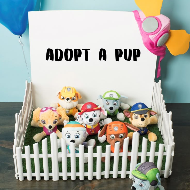 there is a sign that says adopt a pup with lots of stuffed animals in it