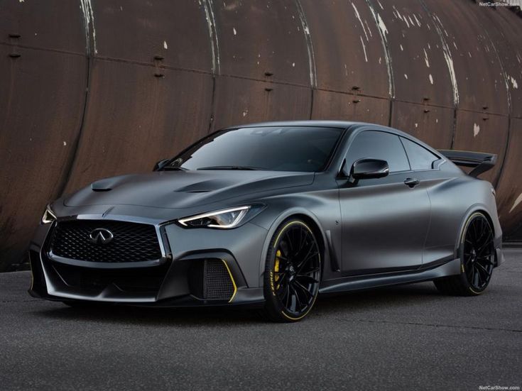 a gray sports car parked in front of a wall