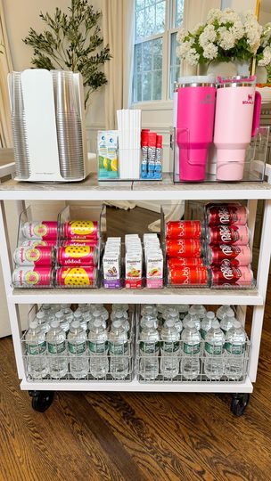 a white cart filled with lots of food and drinks on top of a hard wood floor