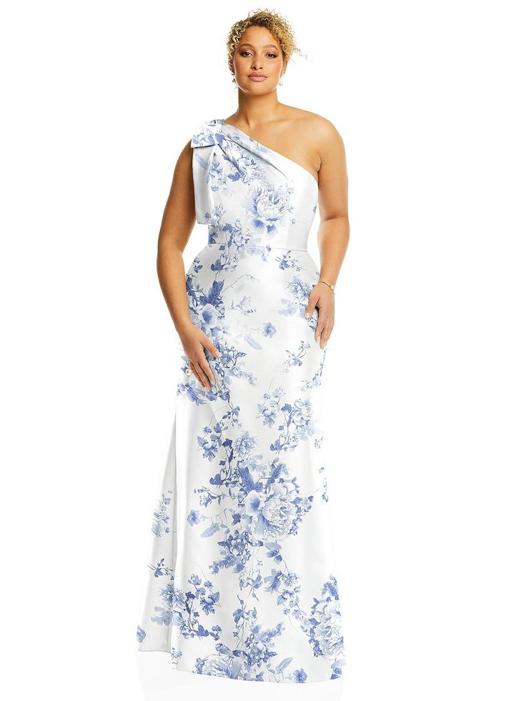 a woman wearing a white and blue dress with flowers on the side, standing in front of a white background