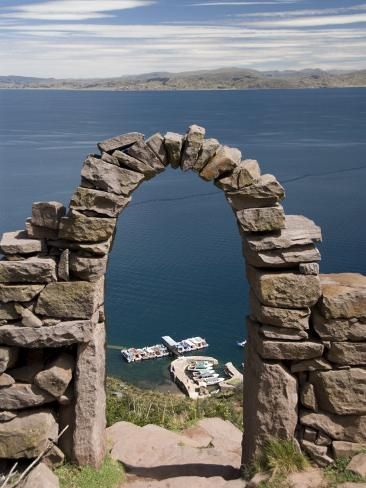 an arch made out of rocks on top of a hill