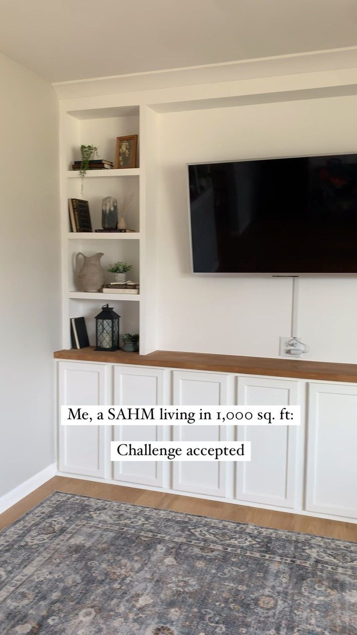 a flat screen tv mounted to the side of a white wall in a living room