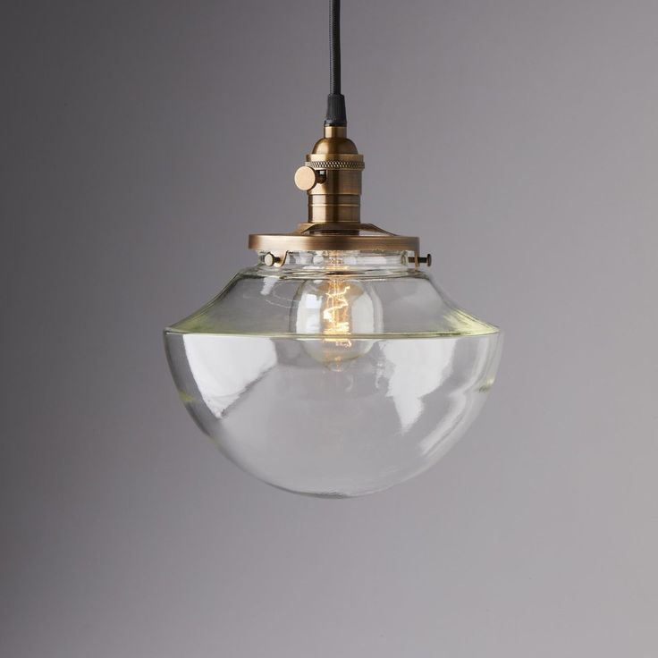 a clear glass globe light hanging from a ceiling fixture with a black cord attached to it