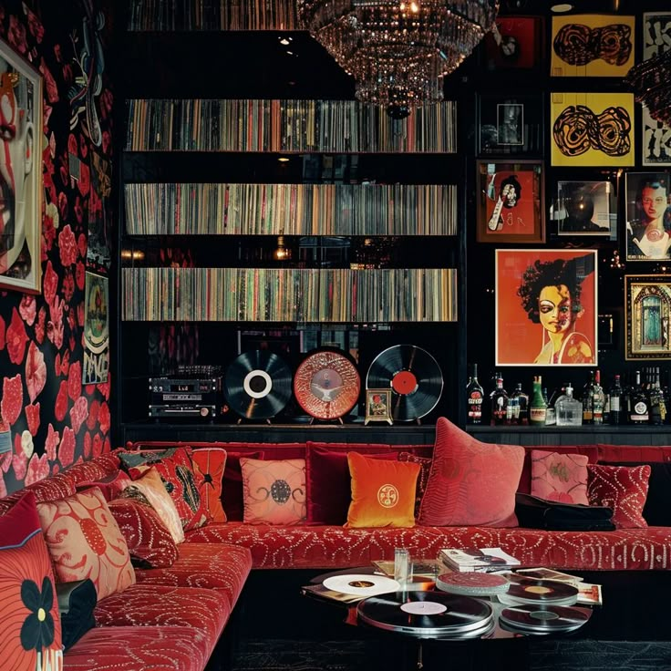 a living room filled with red couches and lots of records on the wall behind them