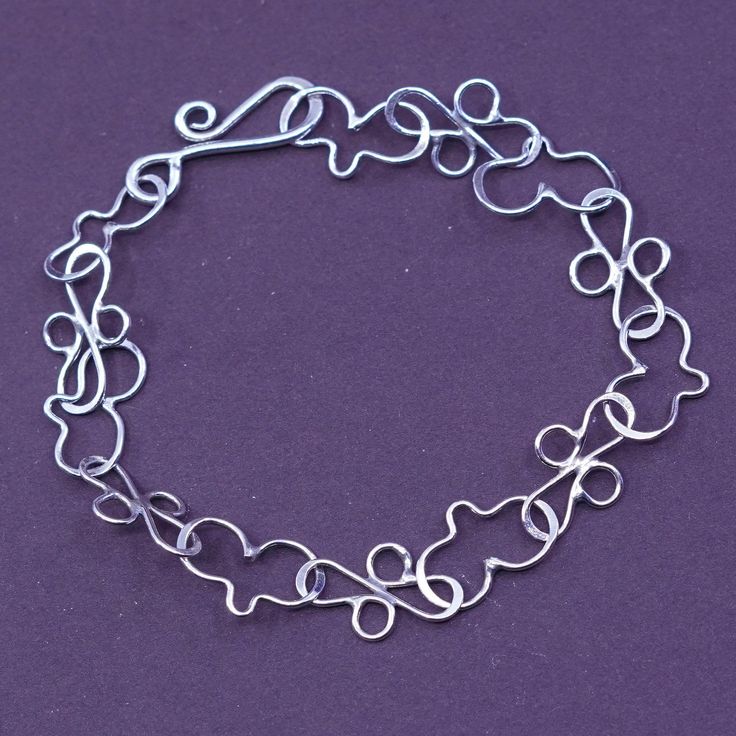 a silver bracelet on a purple background